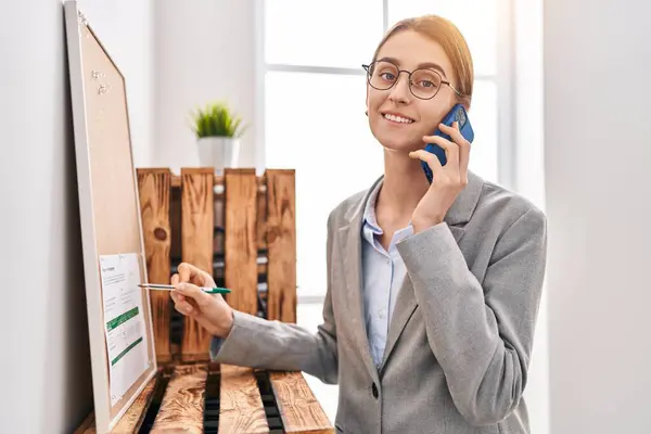 Young Caucasian Woman Business Worker Writing Cork Board Talking Smartphone — Stock Photo, Image