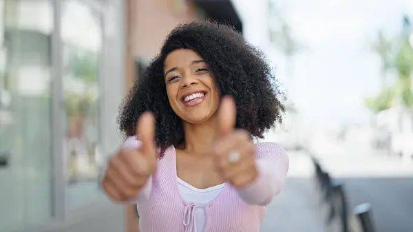 Mujer Afroamericana Sonriendo Confiado Haciendo Signo Con Pulgares Arriba Calle —  Fotos de Stock
