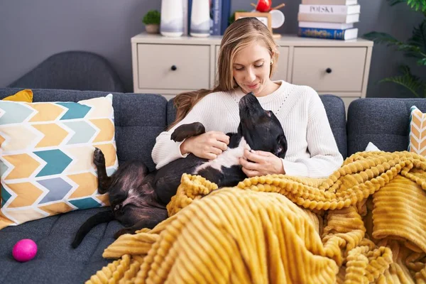 Young Blonde Woman Hugging Dog Sitting Sofa Home — Stockfoto