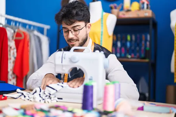 stock image Young hispanic man tailor smiling confident using sewing machine at sewing studio