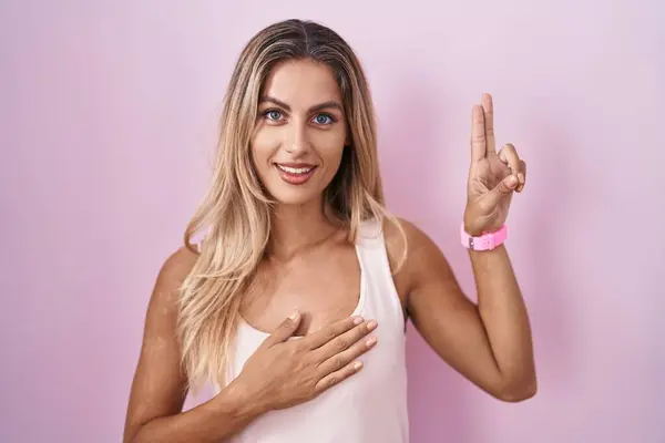 Young Blonde Woman Standing Pink Background Smiling Swearing Hand Chest — Stockfoto