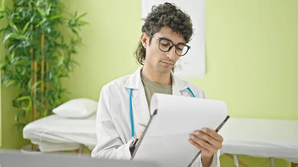 Young Hispanic Man Doctor Writing Medical Report Clinic — Stock Photo, Image