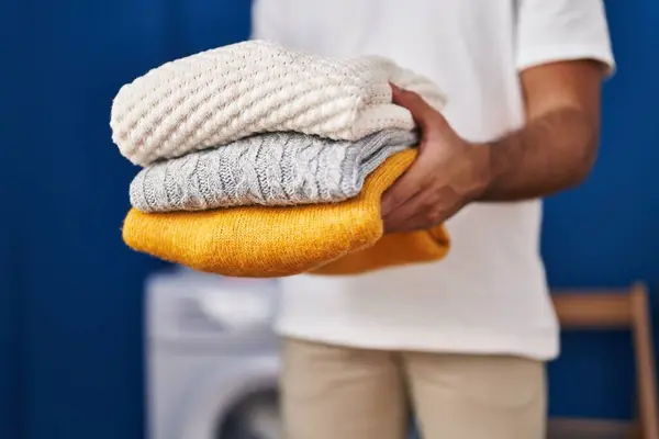 Ung Latinamerikan Man Som Håller Vikta Kläder Tvättstugan — Stockfoto