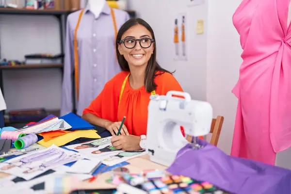 在裁缝店里 年轻美丽的惊慌失措的女人在裁缝店里微笑着 自信地画着服装设计 — 图库照片