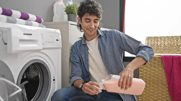 Jonge Spaanse Man Wassen Kleren Gieten Wasmiddel Glimlachen Wasruimte — Stockfoto