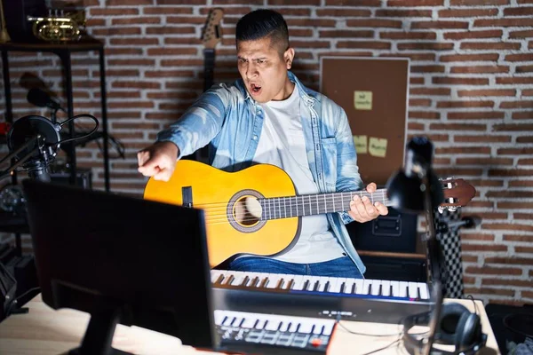 Hispanic Ung Man Spelar Klassisk Gitarr Musikstudio Pekar Missnöjd Och — Stockfoto
