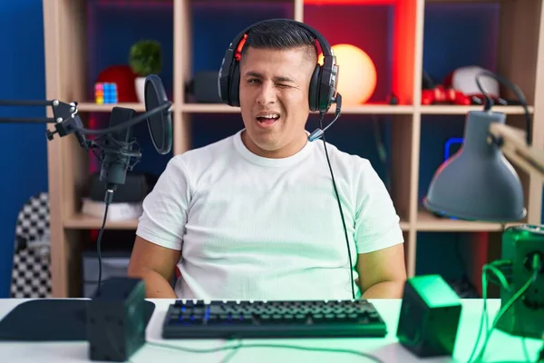 Young Hispanic Man Playing Video Games Winking Looking Camera Sexy — Stok fotoğraf