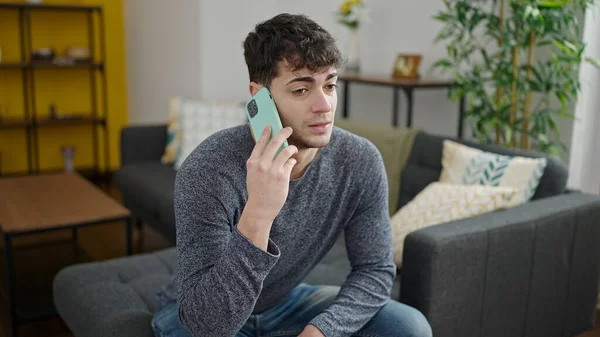 Jovem Hispânico Falando Telefone Sentado Sofá Casa — Fotografia de Stock