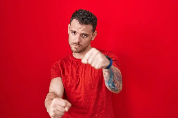Young Hispanic Man Standing Red Background Punching Fist Fight Aggressive — Foto Stock