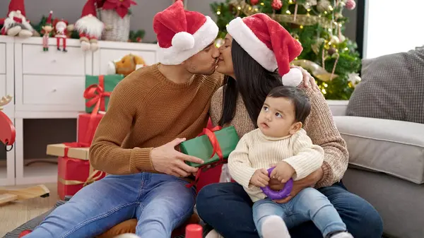 カップルと息子は 自宅でクリスマスツリーで床に座って贈り物を保持しています — ストック写真