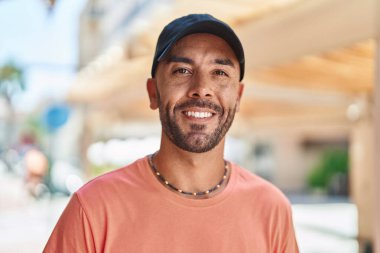 Genç kel adam gülümsüyor. Kendine güveniyor.