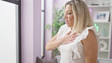 Genç sarışın kadın evinde kalp ağrısı çekiyor.