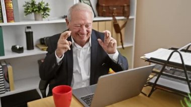 Gülümseyen kıdemli adam, şanslı bir işçi olarak ofiste başarıyı kutluyor.