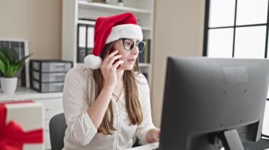Genç, güzel, İspanyol bir iş adamı akıllı telefondan Noel 'i ofisinde kutluyor.