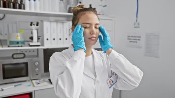 穿着科学家制服的紧张的年轻惊慌失措的女人在实验室里头痛得很厉害 — 图库视频影像