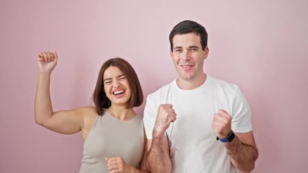 Schönes Paar Lächelt Selbstbewusst Zusammen Und Feiert Vor Isoliertem Rosa — Stockvideo