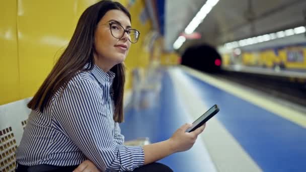 在马德里地铁站 年轻美丽的惊慌失措的女人正在用智能手机等地铁 — 图库视频影像