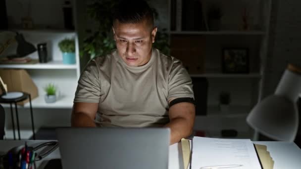 自信的年轻拉丁裔男人快乐地在办公室工作到很晚 微笑着在网上找到了成功 这位快乐的员工专心致志于笔记本电脑 在室内散发着积极的能量 — 图库视频影像
