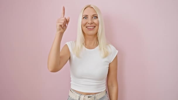 Femeie Tânără Blonda Veselă Ținând Degetul Sus Îndreptându Spre Patinoare — Videoclip de stoc