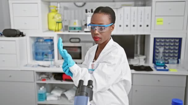 真剣なアフリカ系アメリカ人女性科学者 すべての安全手袋は 騒々しい実験室内の医療試験管のハイステーク分析に深く魅了され 生物学研究フロンティアの限界を押し広げました — ストック動画