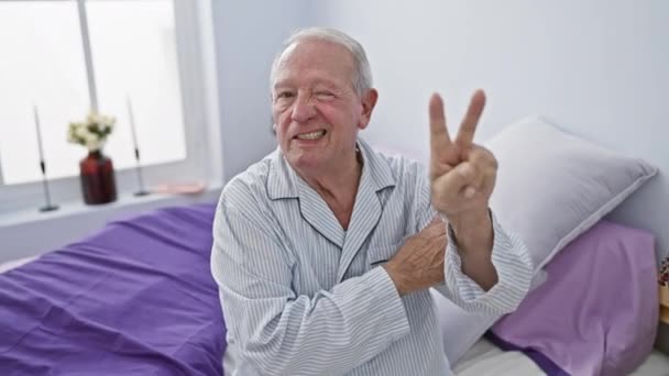 Vrolijke Senior Man Zit Slaapkamer Lachend Zegevierend Met Een Knipoog — Stockvideo