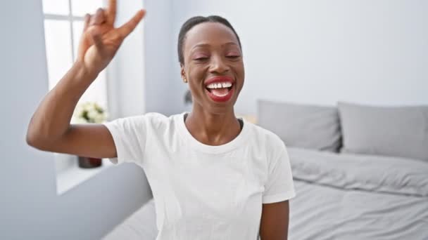 Χαρούμενη Αφροαμερικάνα Που Χαλαρώνει Στην Κρεβατοκάμαρα Δείχνοντας Σύμβολο Της Ειρήνης — Αρχείο Βίντεο