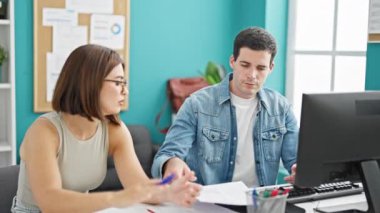 Masada oturan iki işçi ve kadın ofiste stres altında kitap okuyorlar.