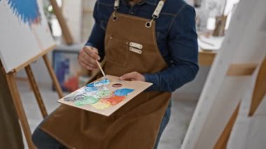 Kendine güvenen mutlu İspanyol genç adam, sanat stüdyolarında çalışan ressam. 