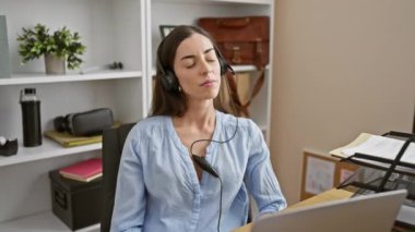 Utangaç ama çarpıcı, ofisteki genç İspanyol kadın şaşırmış, yüzüne korku kazınmış. Örtülü elinin parmaklarından, kulaklıklarından, gözlerine zar zor inandı..