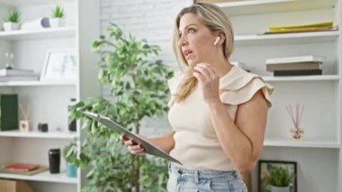 Genç sarışın iş kadını, belgeyi okuyor. Ofisten ücretsiz arama yapıyor.