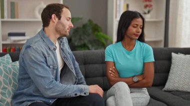 Güzel bir çift kanepede oturup birbirlerine sarılıyor ve evde barışıyorlar.