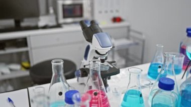 Laboratuvarda mikroskop kullanan orta yaşlı bilim adamı.