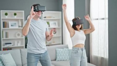 Evde sanal gerçeklik gözlüğü kullanarak dans eden güzel bir çift.