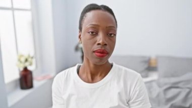 Savaşmaya hazır, güçlü Afro-Amerikan kadın yatakta uzanıyor, yumruğunu yatak odası problemlerine karşı savunmaya hazır.