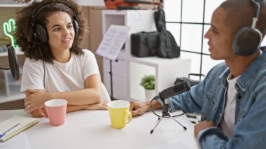 Radyo stüdyosundan canlı yayındayız. Birlikte çalışan gülümseyen muhabirler. Perçinleyici bir röportaj için kulaklık takıyorlar.