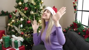 Genç sarışın kadın Noel ağacının yanında duruyor evde dans ediyor