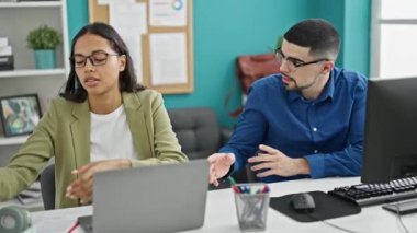 İş yerinde birbiriyle çelişen titreşimler, iç mekan çalışanları, erkek ve kadın, bir ofis masasında oturan, kulaklık takan, çatışmaları yönetmeye çalışan