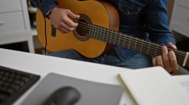 Tutkulu genç İspanyol bir adam, klasik bir gitarist, bir müzik stüdyosunda bir melodi çalıyor, şarkının akorlarda akmasına izin veriyor.