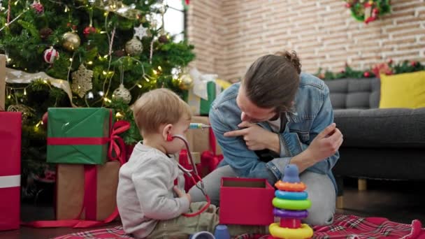 Отец Сын Распаковывают Рождественский Подарок Играя Врачом Игры Дома — стоковое видео