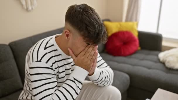 焦虑的年轻人独自坐在沙发上 感到悲伤和沮丧 因头疼和焦虑而陷入绝望 — 图库视频影像