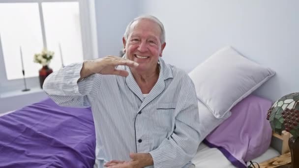 高大明亮的时刻 穿着睡衣的快乐的老人给大尺寸的标志打了个手势 从他舒适的卧室里就能看到规模巨大的杰作 — 图库视频影像