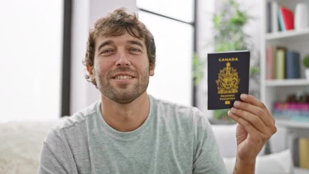 Jovem Feliz Sorrindo Sentado Casa Sofá Segurando Seu Passaporte Canadense — Vídeo de Stock