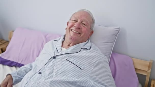 Hombre Mayor Sonriente Rebosante Positividad Sentado Una Cama Acogedora Casa — Vídeo de stock