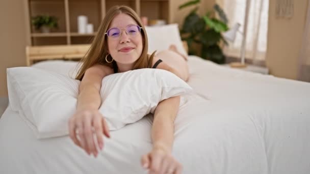 Jovem Loira Sorrindo Confiante Deitado Cama Olhando Sexy Quarto — Vídeo de Stock