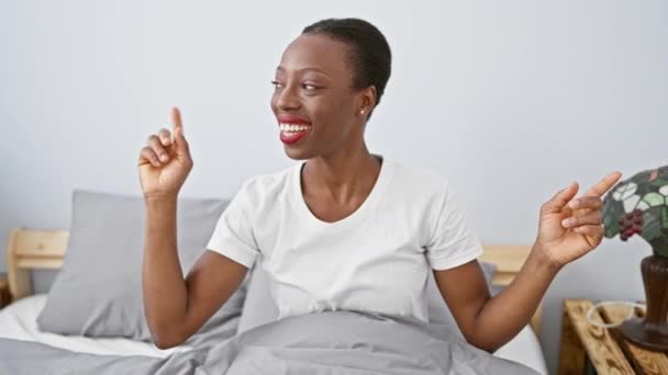 Afroamerikanerin Die Auf Dem Bett Liegt Lächelt Selbstbewusst Und Zeigt — Stockvideo