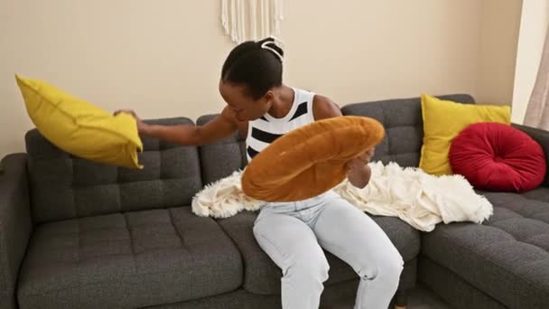 自宅で居心地の良いソファーで快適に休む美しいアフリカ系アメリカ人女性は リビングルームでリラックスした表情で何かを探しています — ストック動画