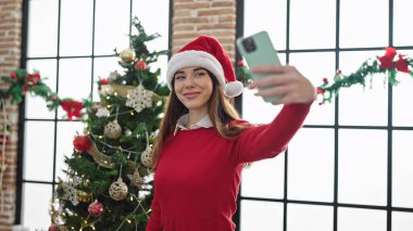 Genç İspanyol kadın evde Noel 'i kutlarken selfie çekiyor.