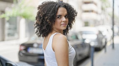 Sokakta ciddi bir ifadeyle duran genç, güzel İspanyol kadın.