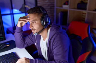 İspanyol asıllı genç adam oyun odasında bilgisayar kullanarak strese girdi.