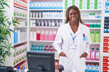 Eczanede kendine gülen Afrikalı Amerikalı kadın eczacı.